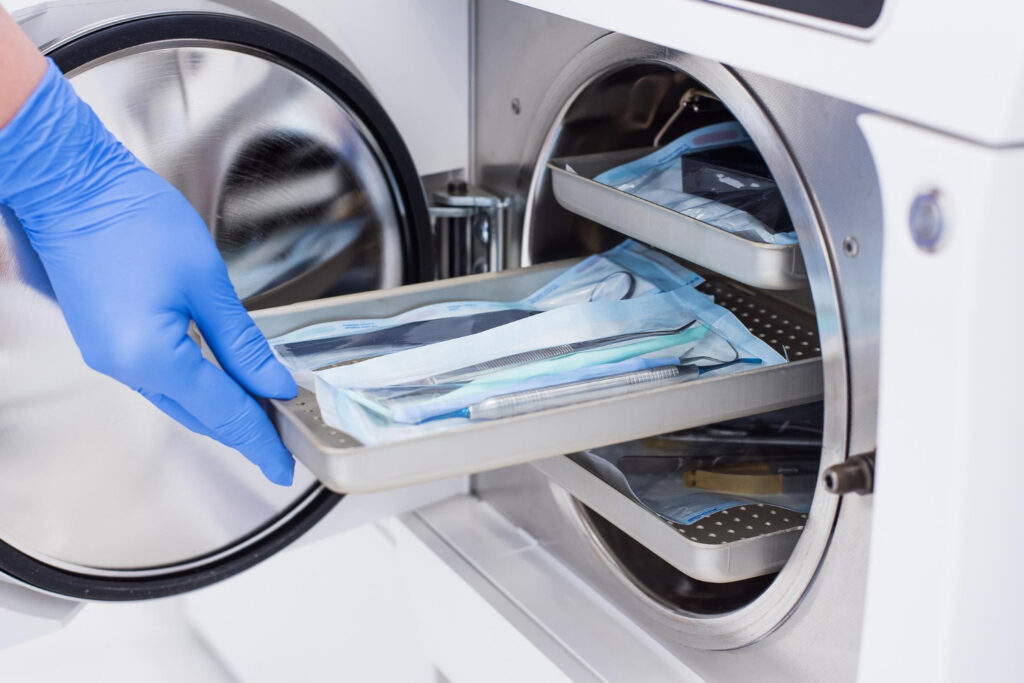 Profissional retirando material da autoclave após resfriamento. - Curso Manutenção Autoclave