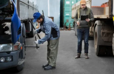 Durante a verificação mecânica, o operador observa conexões e sistemas hidráulicos, assegurando estabilidade e funcionalidade antes da operação de transporte.