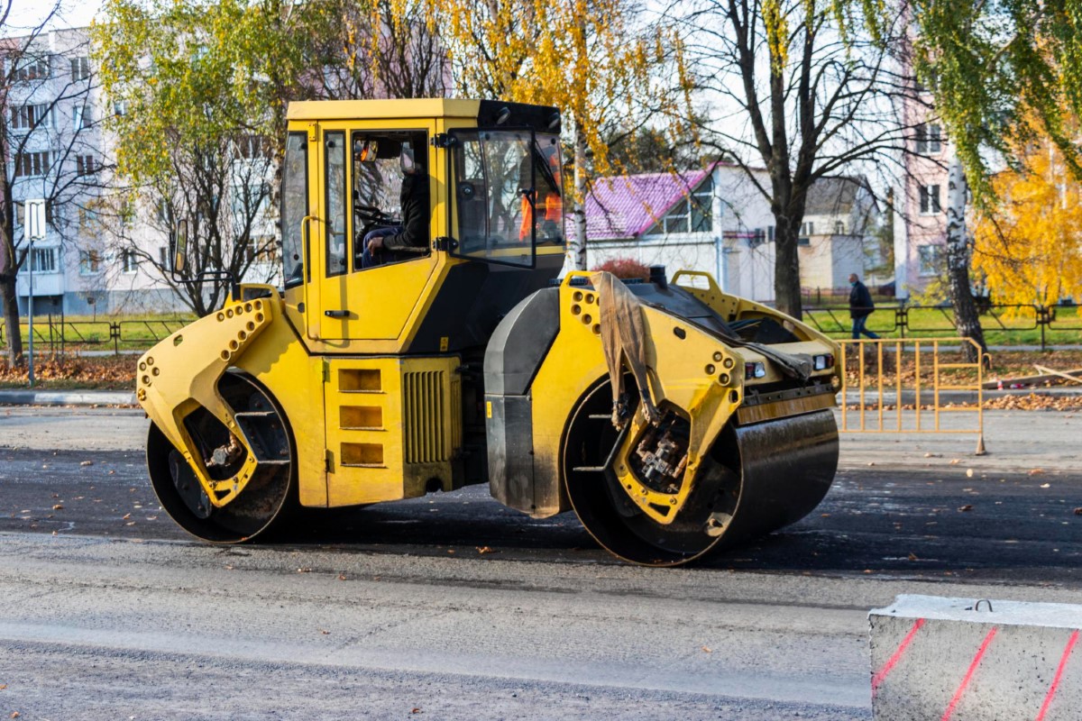 Operação do rolo compactador em superfície asfáltica, destacando estabilidade, visibilidade e condução segura.