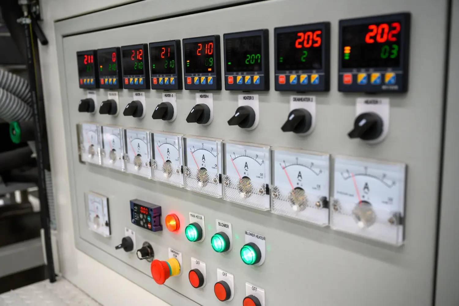 Painel de controle com indicadores analógicos e digitais para monitoramento de corrente e temperatura.