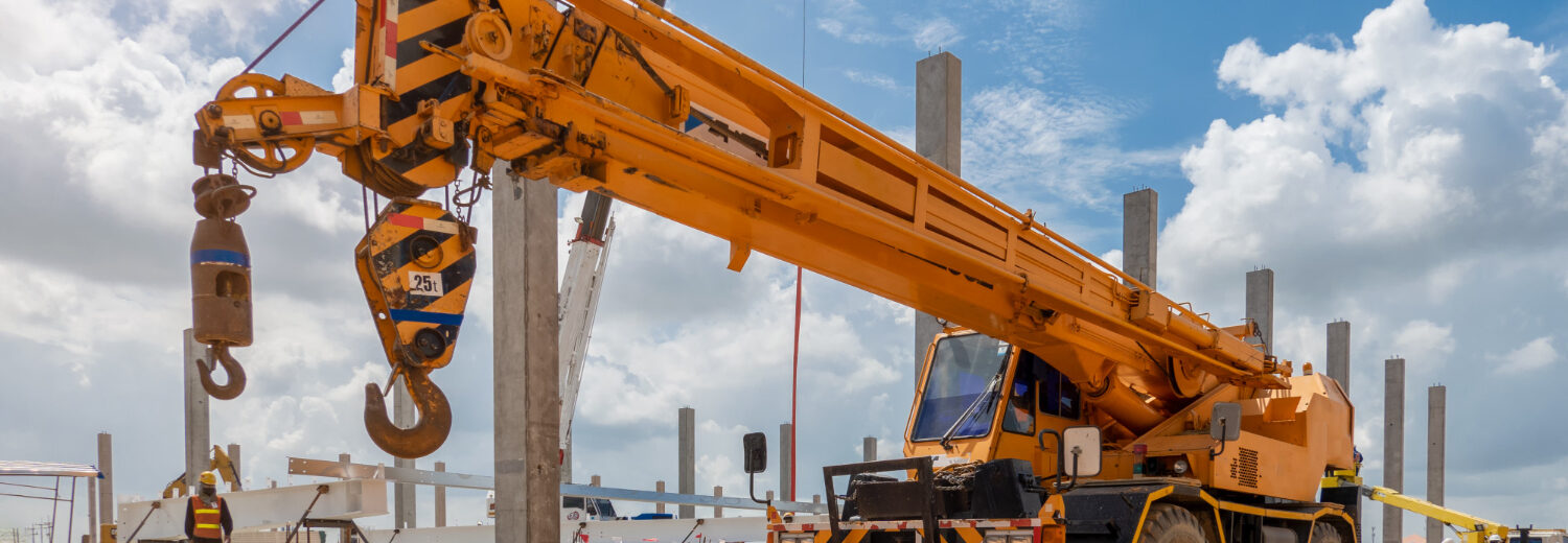 Guindaste telescópico sobre rodas em operação em canteiro de obras - Curso Laudo de Guindaste