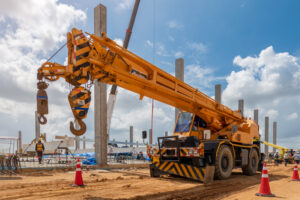 Guindaste telescópico sobre rodas em operação em canteiro de obras - Curso Laudo de Guindaste