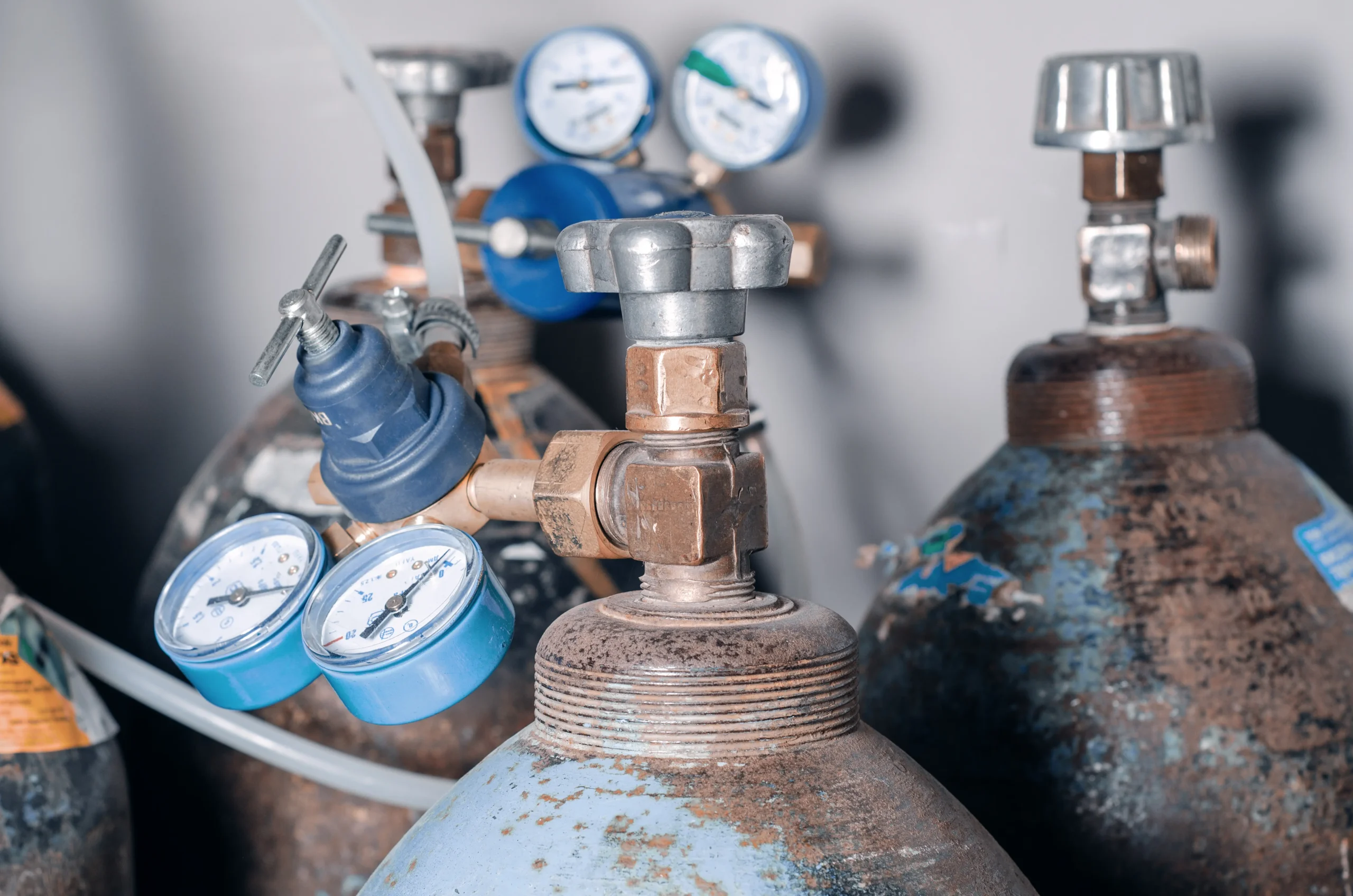 DESTAQUE Cilindros de gases medicinais com reguladores e manômetros instalados, evidenciando pontos críticos de inspeção, controle de pressão e procedimentos de manutenção segura conforme ABNT NBR 12188 e boas práticas de operação em sistemas hospitalares.