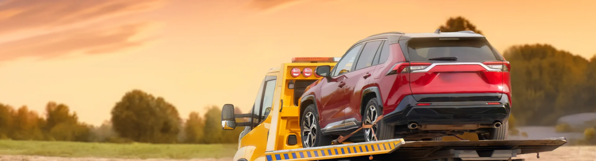 O guincho realiza o transporte seguro do veículo ao entardecer, simbolizando o equilíbrio entre técnica, atenção e responsabilidade contínua do operador.