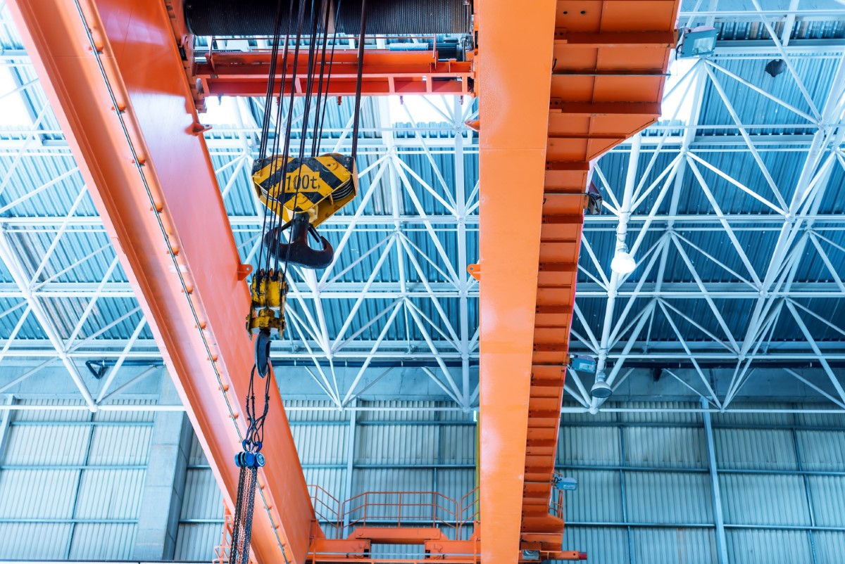 Bridge crane operating inside an industrial facility, illustrating critical safety concepts related to overhead movement, exclusion zones and suspended load control.