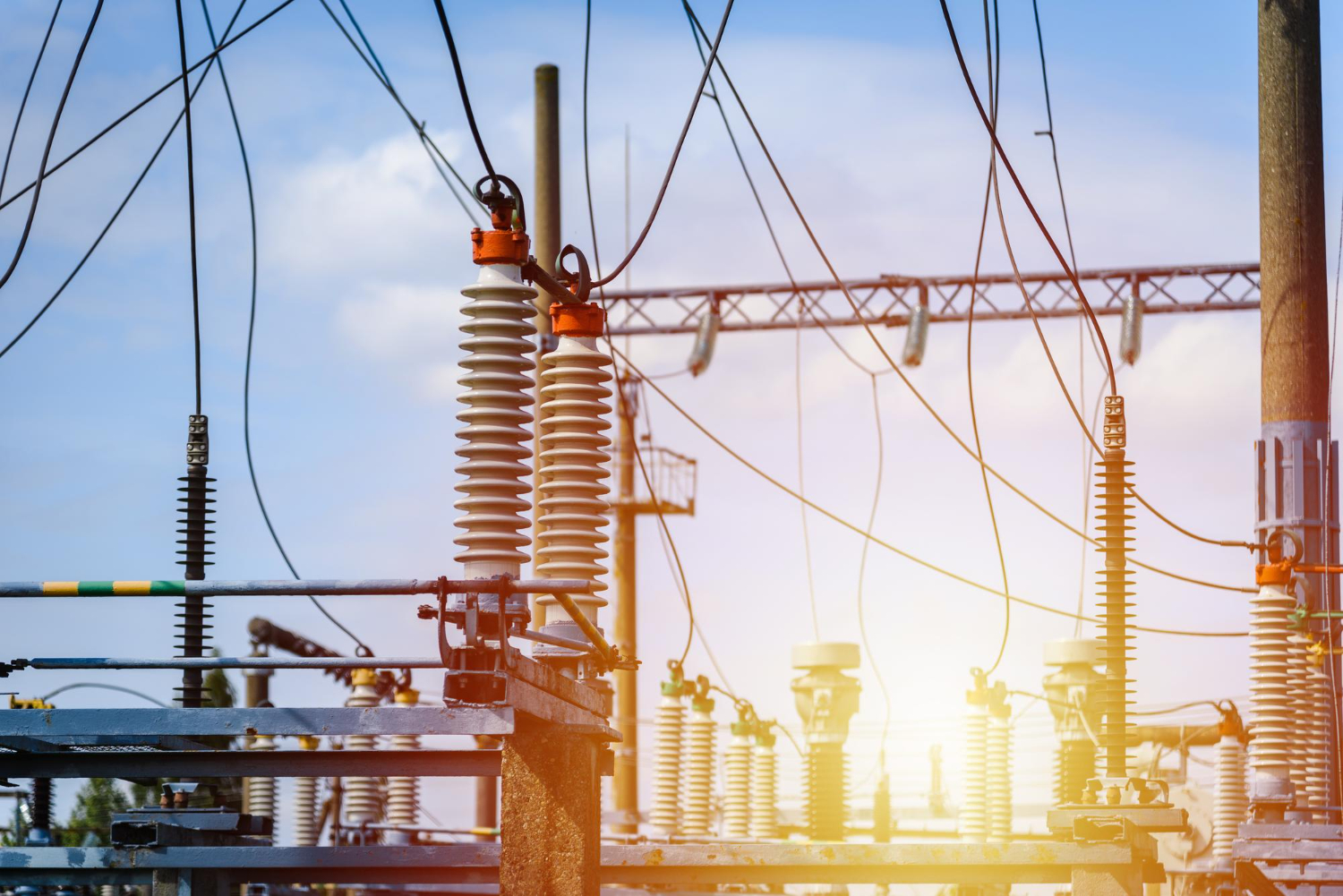 Estrutura típica de subestação aérea de média tensão com isoladores de porcelana e cabos rígidos. O sistema garante a distribuição segura da energia elétrica e permite manobras de seccionamento em campo aberto.