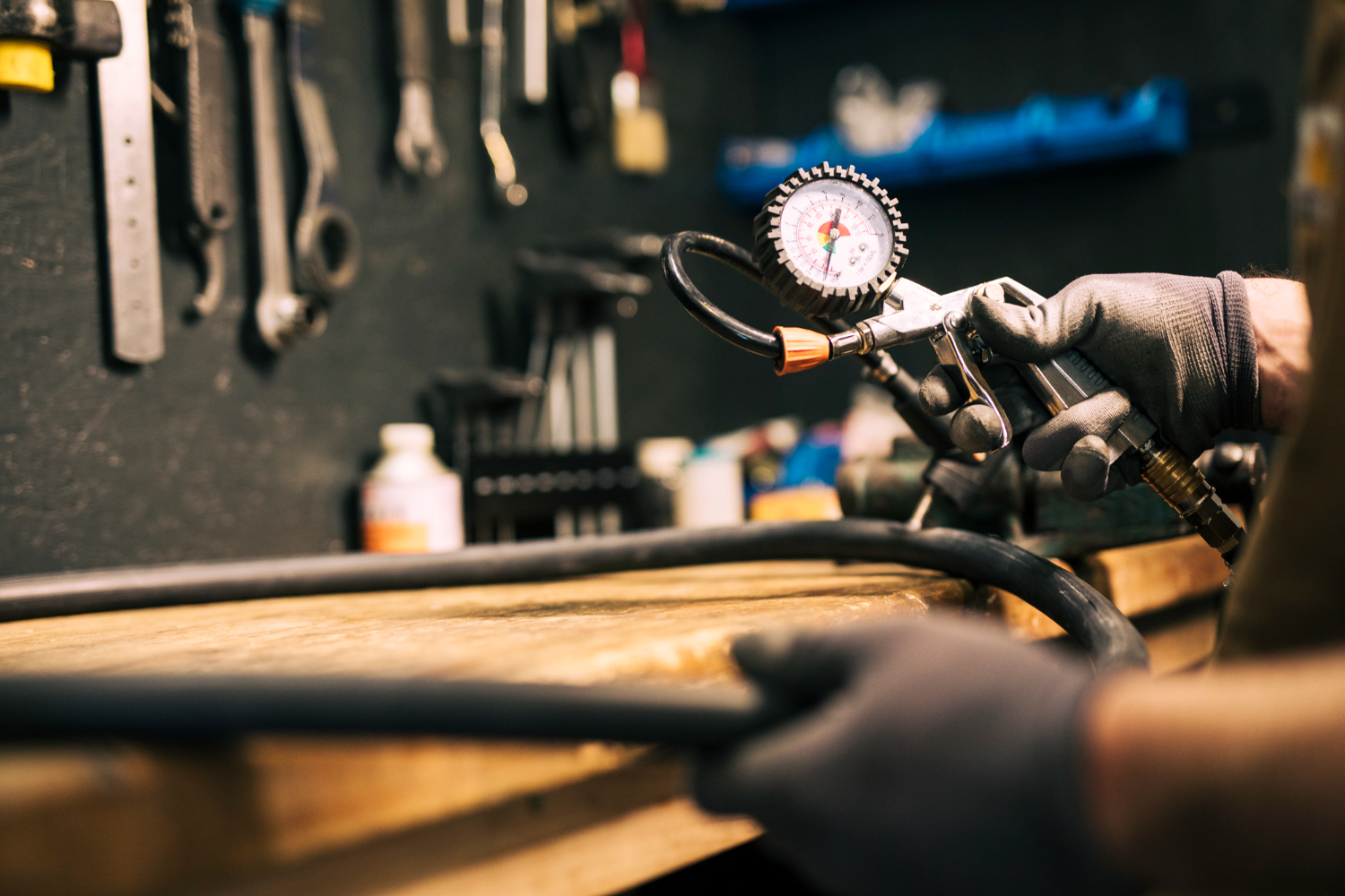 Técnico manuseia pistola pneumática com manômetro em bancada de oficina - Curso Elaborar Laudo de Compressor
