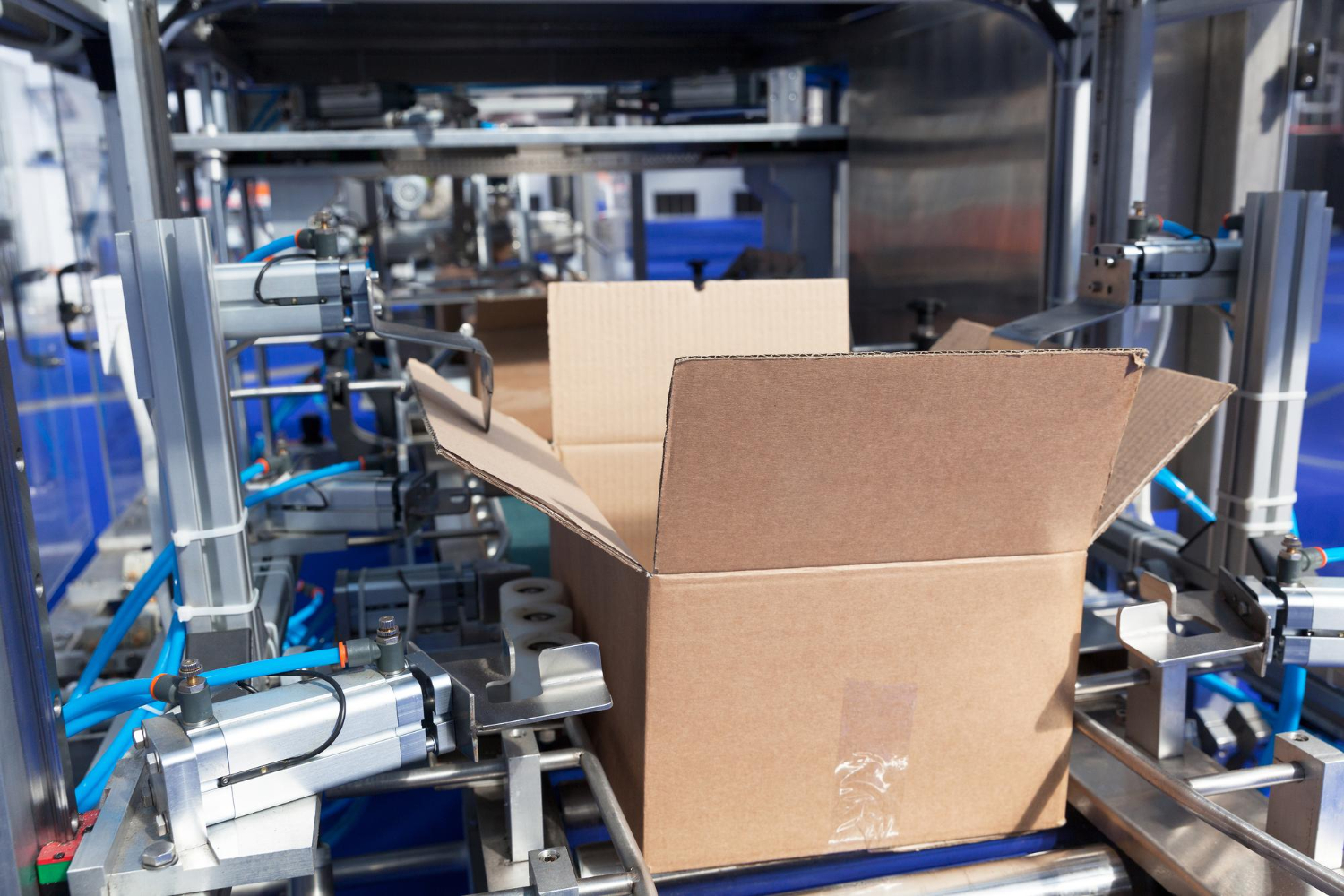 Máquina embaladora automatizada montando caixas de papelão, destacando componentes de segurança e precisão no processo - Laudo de Máquina Embaladora.