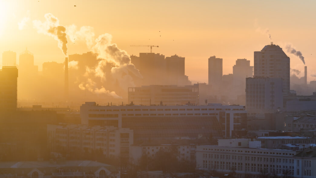 Amanhecer sobre a cidade. O sol ilumina a poluição sobre a cidade. -Consultoria Qualidade do Ar