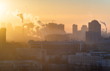 Poluição sobre a cidade Amanhecer sobre a cidade. O sol ilumina a poluição sobre a cidade. -Consultoria Qualidade do Ar