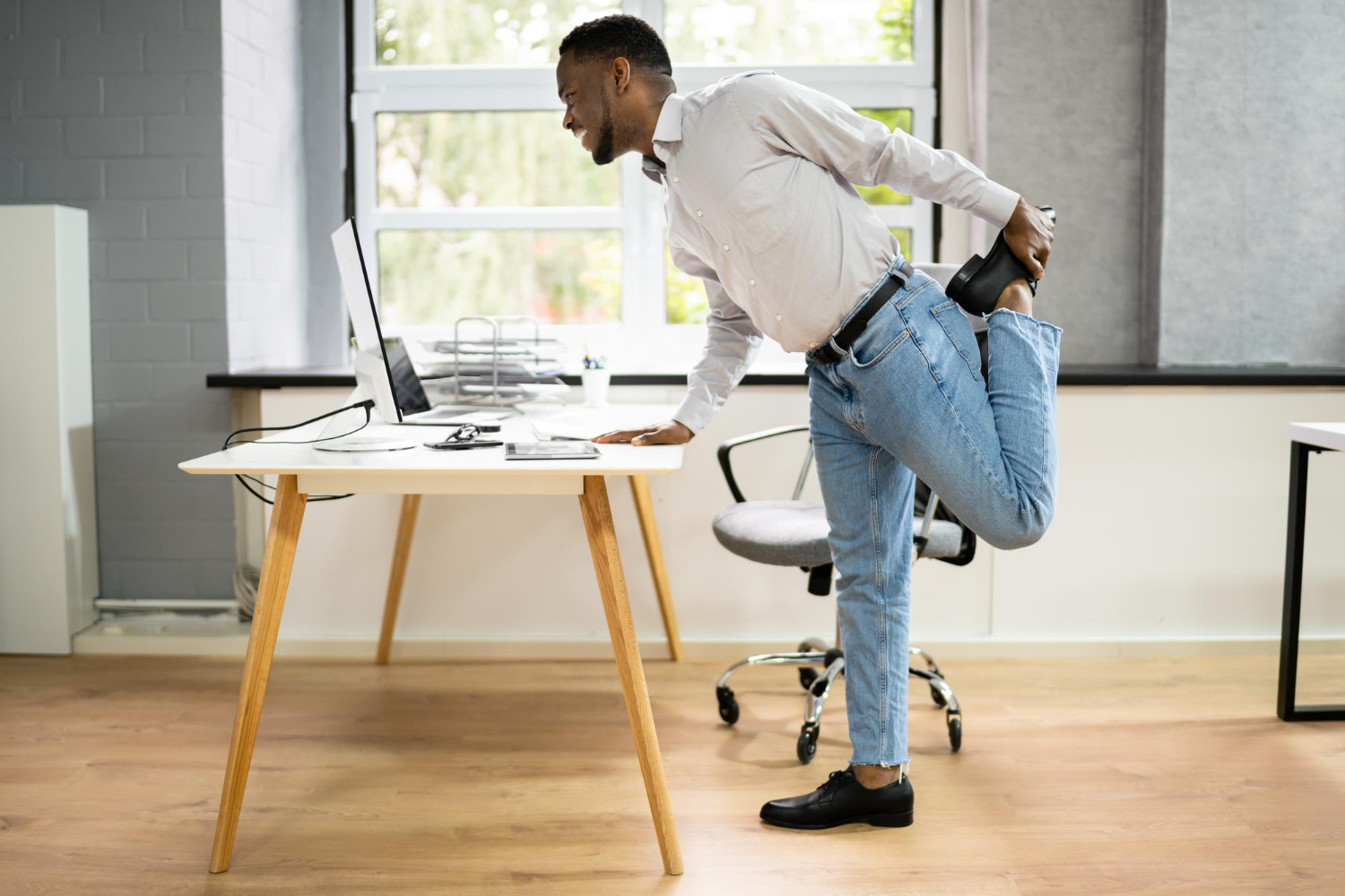Incorpore alongamentos simples no seu dia de trabalho, como puxar o tornozelo para trás, para manter a flexibilidade e reduzir a rigidez muscular. - Curso NR 17.