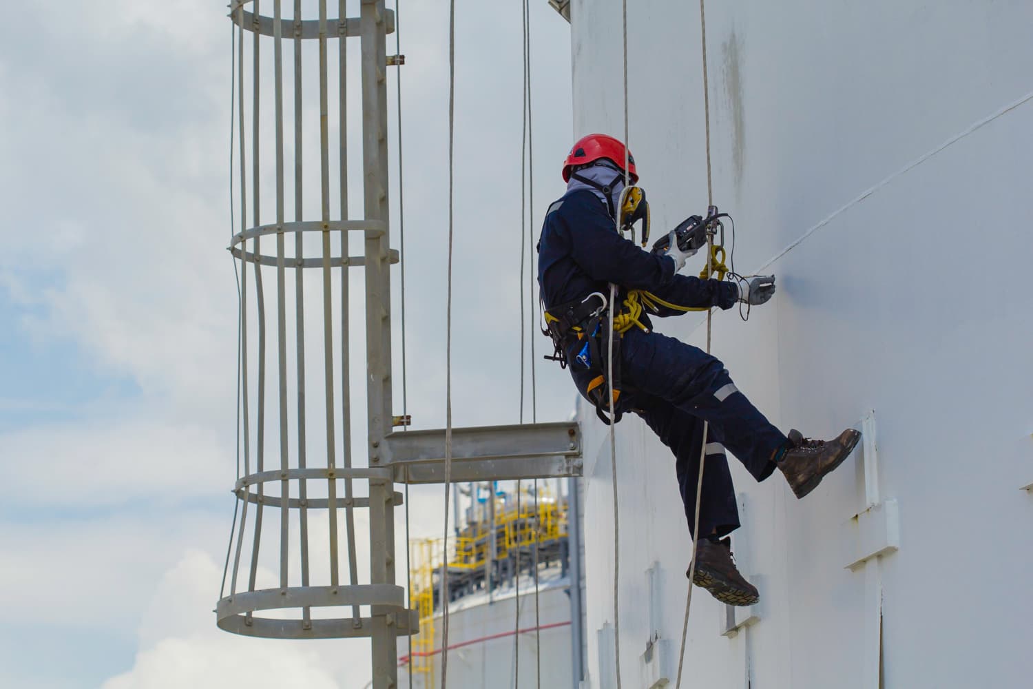 Trabalho industrial vertical com cadeira suspensa: uso correto de EPIs, sistema de trava-quedas e capacitação técnica são barreiras reais contra quedas e acidentes fatais.
