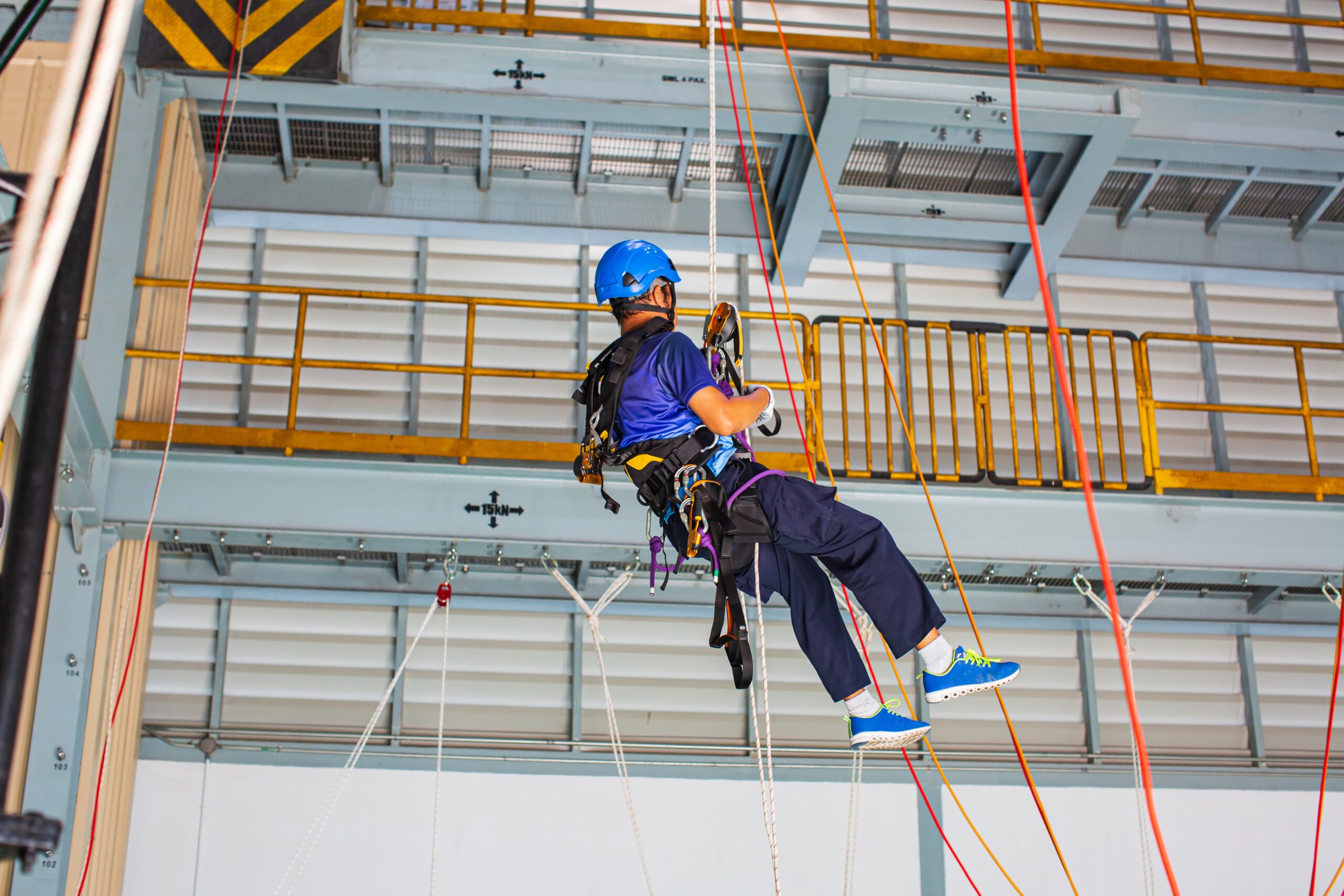 Treinamento prático com cadeira suspensa em ambiente indoor simulações realistas fortalecem a resposta do trabalhador diante de riscos operacionais em altura.