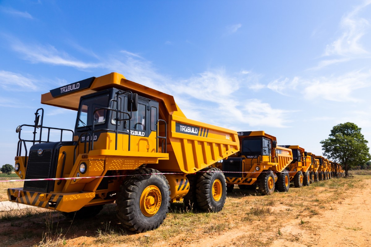 Fleet of off-road haul trucks ready for operation, emphasizing coordinated movement, signaling routines and risk control in material transport.