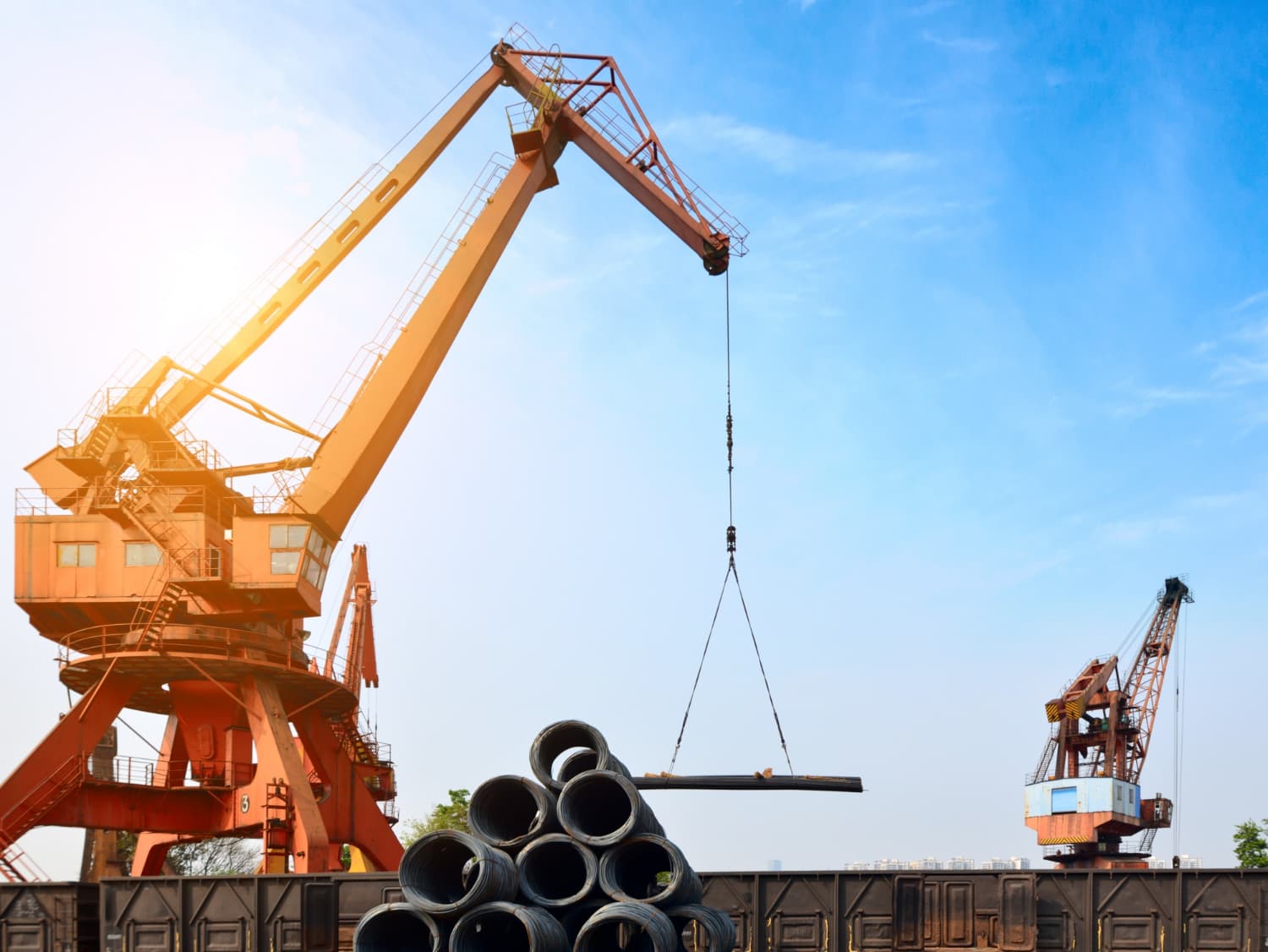 Operação de içamento em zona portuária: cada movimento do guindaste exige controle de estabilidade, linha de carga e comunicação sincronizada.