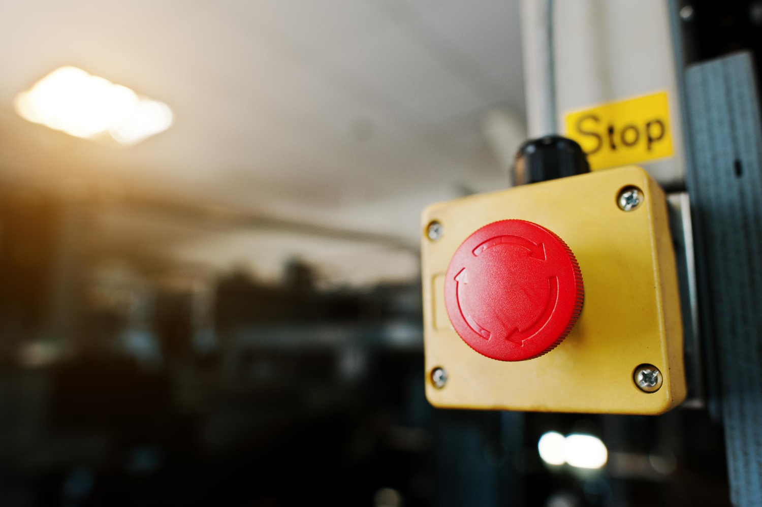 Dispositivo de segurança industrial com botão de parada de emergência tipo cogumelo, utilizado para interromper imediatamente máquinas ou processos perigosos. - NFPA 72 Código Nacional.