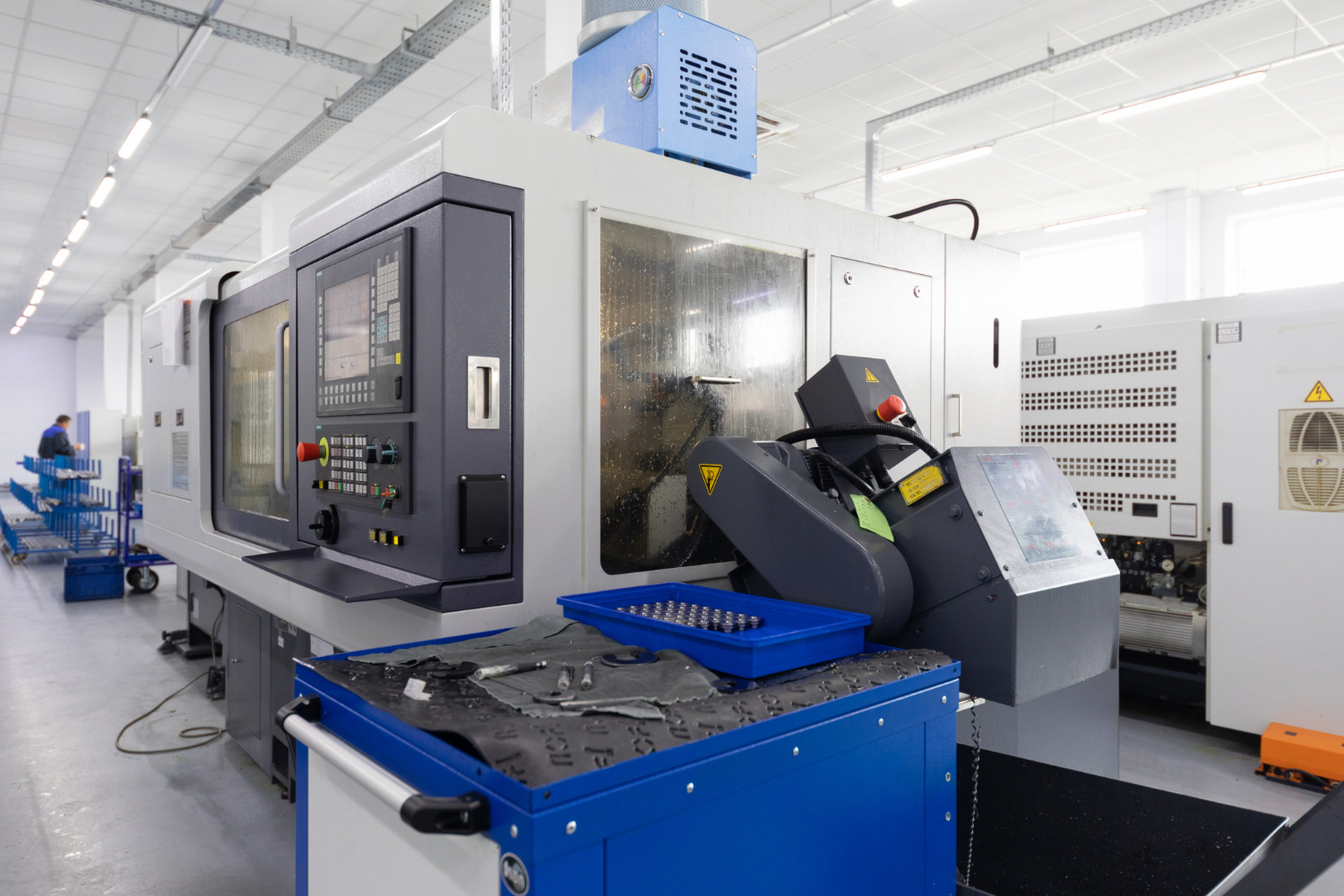 Centro de usinagem CNC operando com proteção fechada, garantindo contenção de cavacos e segurança durante o ciclo de corte.