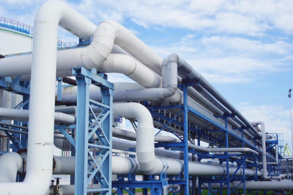 Identifique os principais elementos de segurança e integridade estrutural presentes nesta instalação de tubulações aéreas industriais - Curso de Atmosfera Explosiva EX003