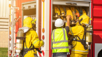 Bombeiros organizando mangueiras no caminhão de combate a incêndios, garantindo que todo o equipamento esteja pronto para a próxima emergência.