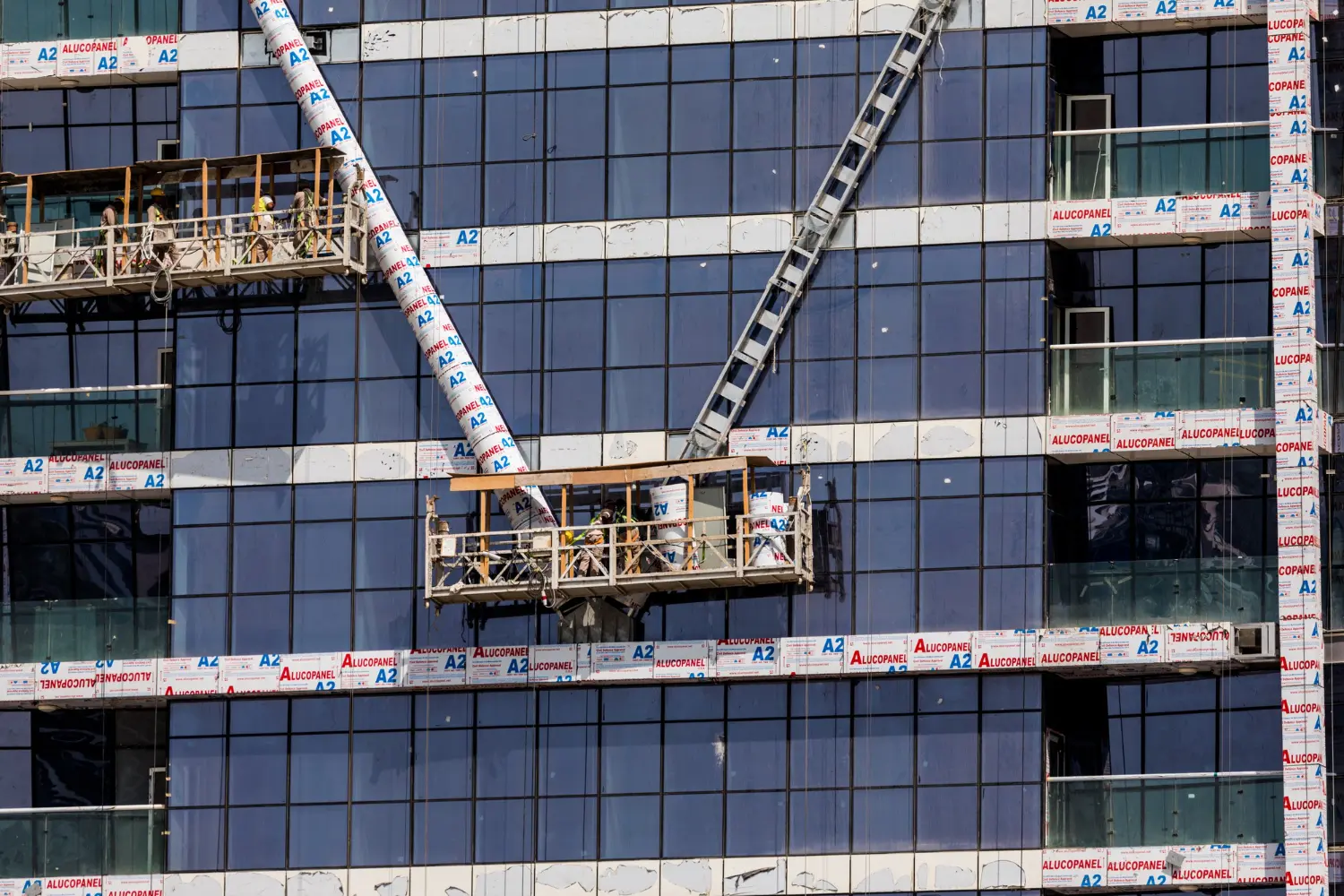 Balancins suspensos em fachada de edifício requerem ancoragem projetada, contrapesos calculados e inspeção diária conforme NR 18.