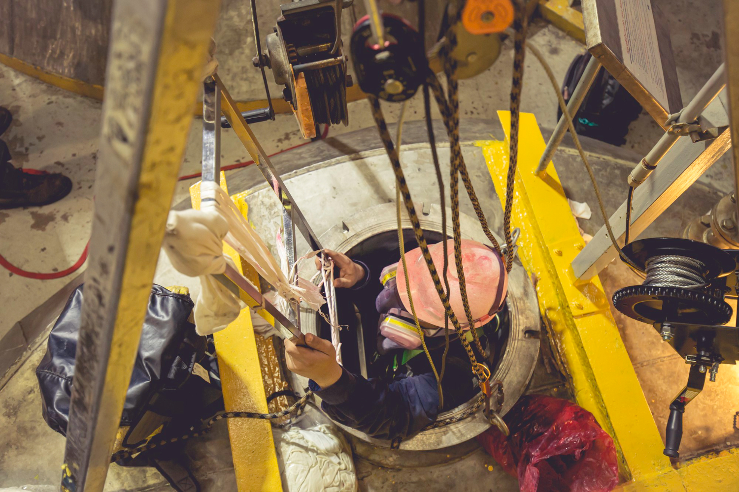 Entrada segura em espaço confinado: Uso adequado de EPIs e sistema de resgate garantem a integridade do trabalhador. - Curso Inventário Espaço Confinado.
