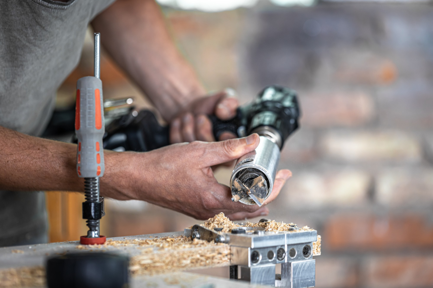 Profissional operando uma furadeira manual equipada com uma broca forstner, ideal para perfuração precisa em madeira, criando cavidades limpas e bem definidas. - Curso Furadeira e Rosqueadeira.