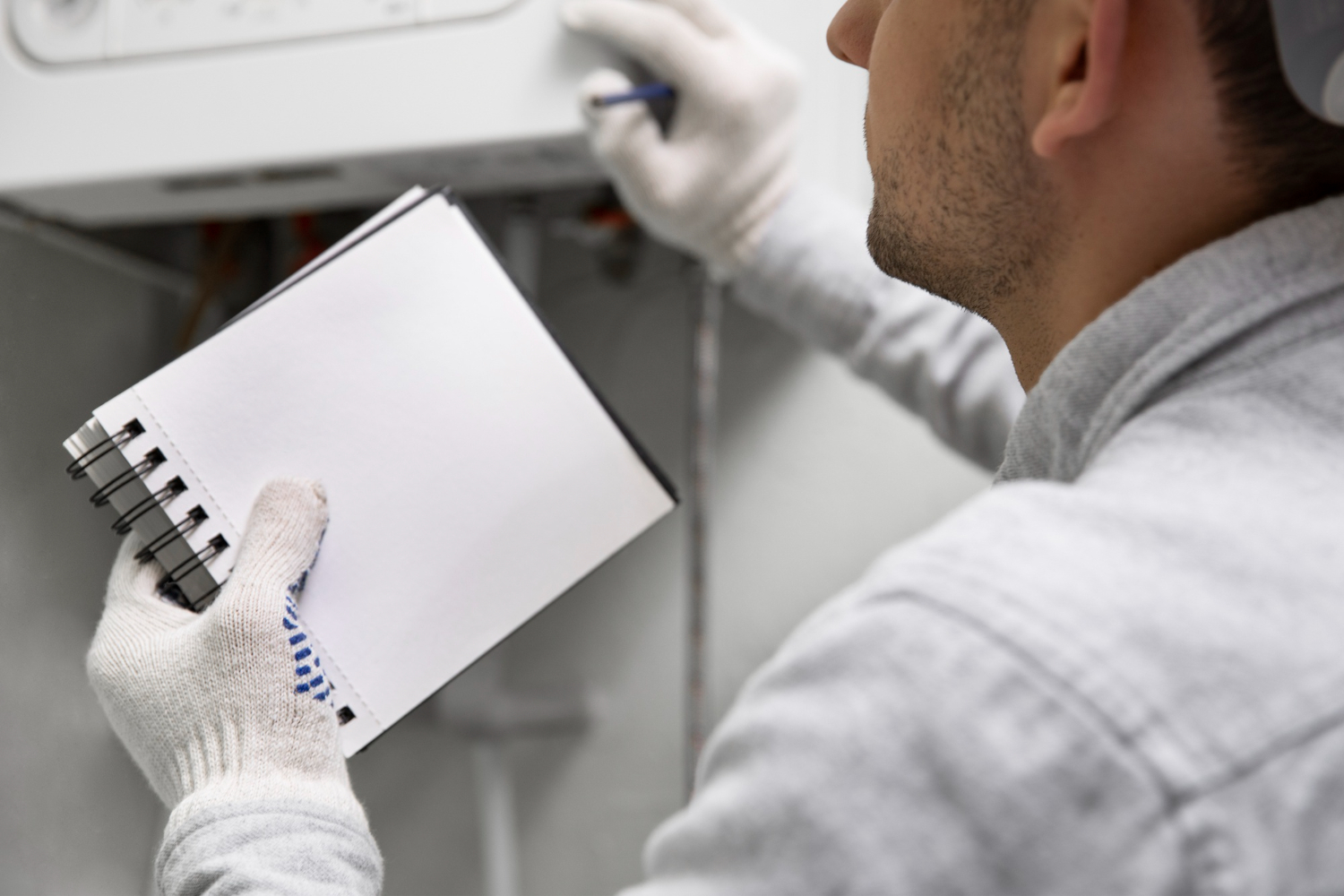Inspeção minuciosa! Técnico faz anotações enquanto verifica sistema de aquecimento. - Curso Como Fazer PMOC.