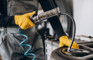 Car mechanic changing wheels in car