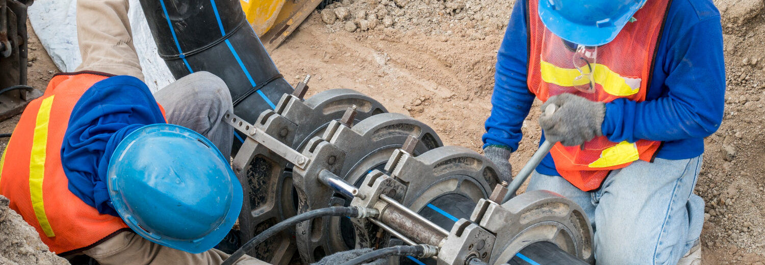 Manutenção Predial: Trabalhadores realizam a fusão de tubulações para minimizar perdas e garantir um fluxo de água eficiente, reduzindo o desperdício e otimizando recursos hídricos.