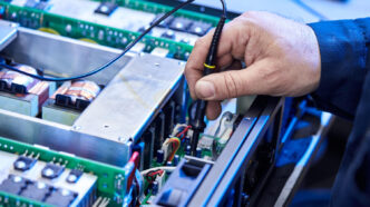 Técnico inspecionando e testando uma unidade de drive elétrico, destacando a importância da manutenção e calibração para garantir a eficiência e segurança operacional. - Curso Manutenção Drives Elétricos.
