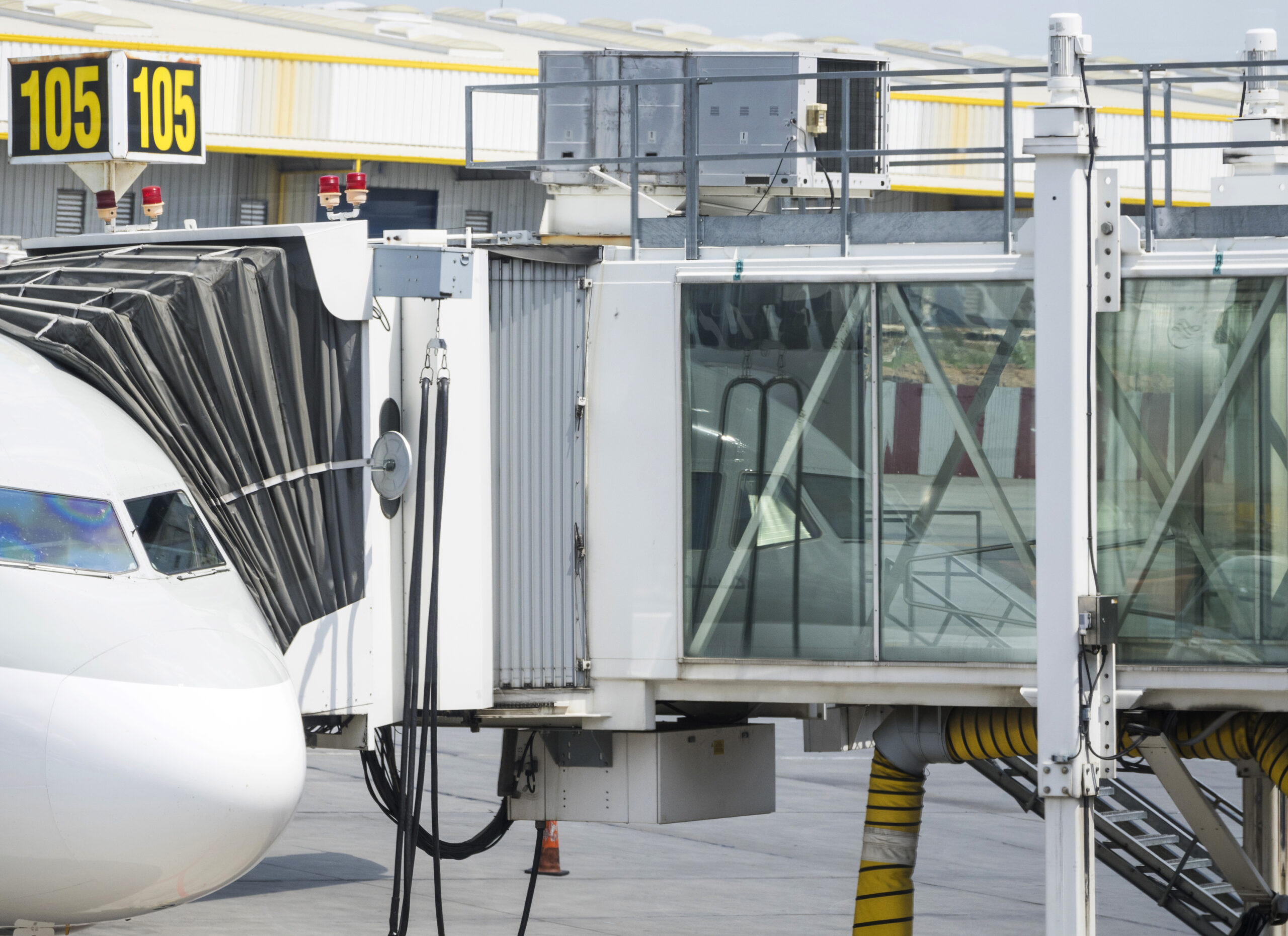 Manga de embarque telescópica conectada diretamente à porta da aeronave. Esse equipamento permite o acesso seguro e protegido dos passageiros, eliminando a exposição às condições climáticas e otimizando o fluxo de embarque e desembarque. - Curso Operador Mangas Embarque.
