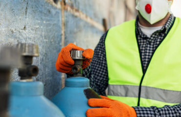 Trabalhador manuseando cilindros de gases industriais com EPIs adequados, reforçando a importância das práticas seguras no manuseio. Trabalhador manuseando cilindros de gases industriais com EPIs adequados, reforçando a importância das práticas seguras no manuseio - Curso Cilindro Gases Industriais.