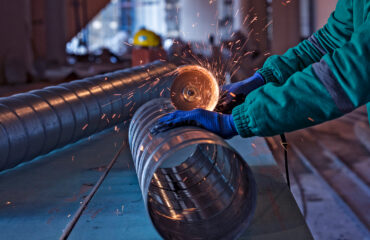 Inspeção de tubulação conforme norma AWWA C206: Trabalhador utilizando ferramenta abrasiva para preparar a superfície da tubulação metálica, garantindo a conformidade com os requisitos de soldagem e acabamento para sistemas de condução de água. O curso Inspeção Solda AWWA C206 visa capacitar os participantes a realizar a inspeção adequada de soldagens em campo em tubos de aço para água, de acordo com as diretrizes da norma AWWA C206:2023. O curso abordará os processos de soldagem manual, semiautomática e automática, focando em diferentes tipos de juntas, como sobrepostas, de topo e butt-strap, aplicáveis à soldagem de tubos em linhas de transmissão e distribuição de água. Além disso, os participantes aprenderão a avaliar a conformidade das soldagens com os requisitos da norma, garantindo a qualidade e segurança na instalação de tubulações. O curso também capacita os profissionais a identificar e corrigir possíveis não conformidades durante o processo de fabricação e instalação em campo.