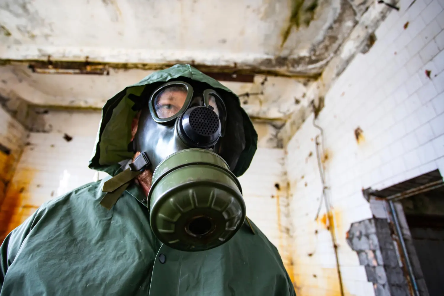 Uso de máscara de proteção integral com filtro químico em ambiente degradado, ilustrando cenários de alta toxicidade e risco respiratório crítico.