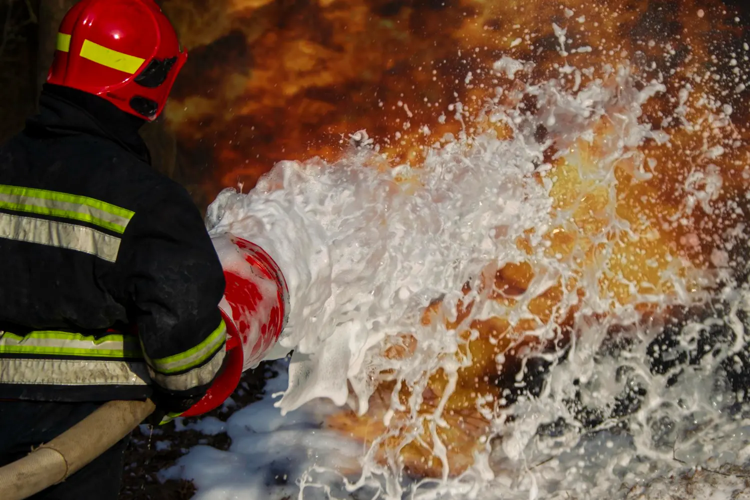 Aplicação em incêndio real com risco classe HC – a espuma AFFF forma barreira de isolamento térmico e bloqueia a liberação de vapores inflamáveis. Eficiência depende do teste técnico de LGE.