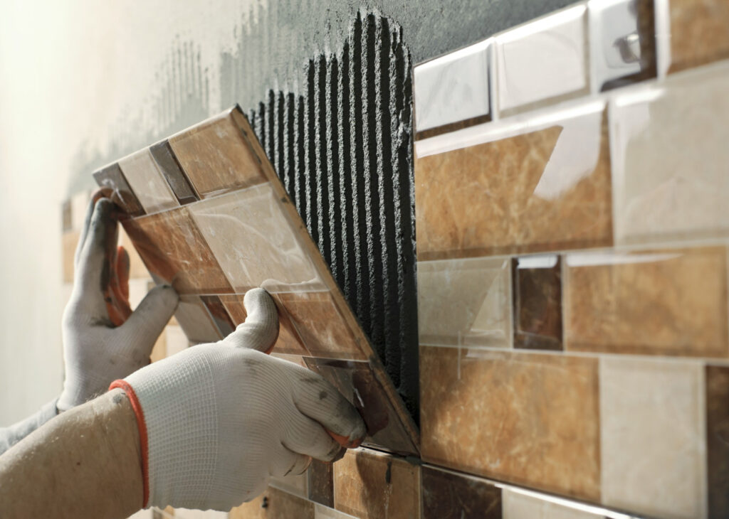 Momento de instalação de placas de cerâmica em parede residencial. - Laudo de Materiais Cerâmicos.