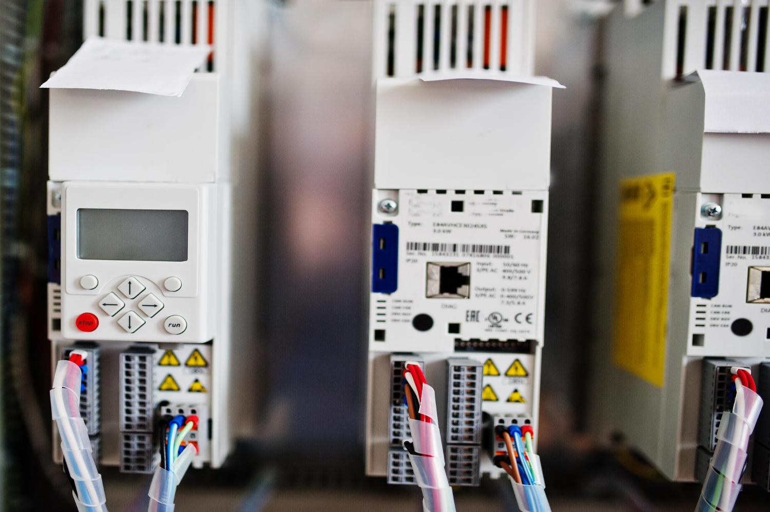 Detalhe de um inversor de frequência em um painel elétrico, demonstrando a importância de componentes tecnológicos no controle e distribuição de energia. - Curso Padrão Entrada Energia.
