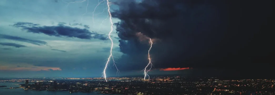 relâmpago sobre cidade simbolizando a proteção do sistema SPDA