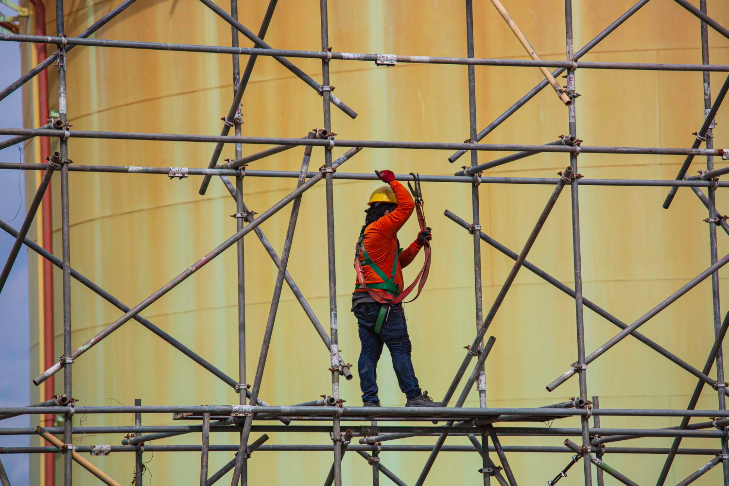 Registro da montagem do andaime multidirecional, com conexão em rosetas e tubos metálicos galvanizados, permitindo variação de ângulos e adaptabilidade à estrutura cilíndrica. Observa-se uso de cinturão de segurança tipo paraquedista, conforme NR-35. Laudo Andaime Multidirecional.