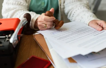 tipos-de-pericia Uma profissional especialista em perícia carimbando documentos que ilustram os tipos de perícia