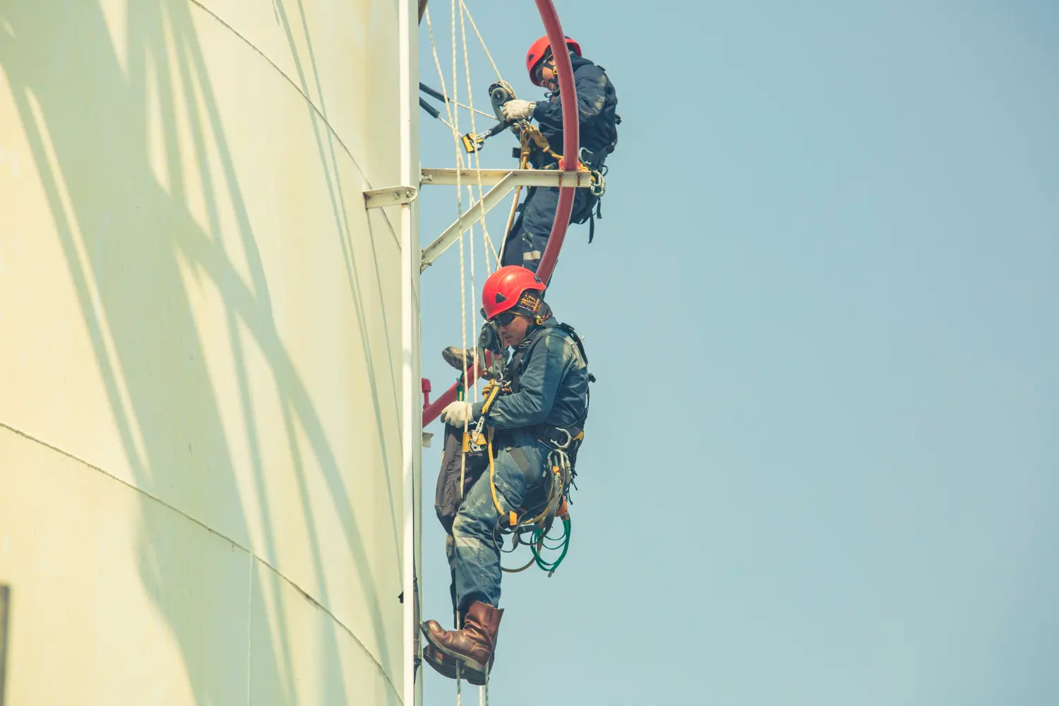 Instrutores em operação segura de acesso por cordas conforme NR-35, com uso correto de talabartes, mosquetões e sistema de ancoragem certificado.