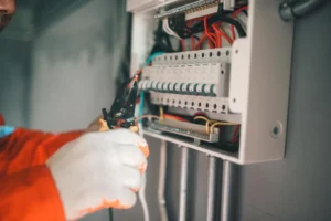 Técnico realiza decapagem de condutores em sistema de proteção com seccionamento visível. O painel está identificado e isolado, como exige o prontuário da instalação elétrica.