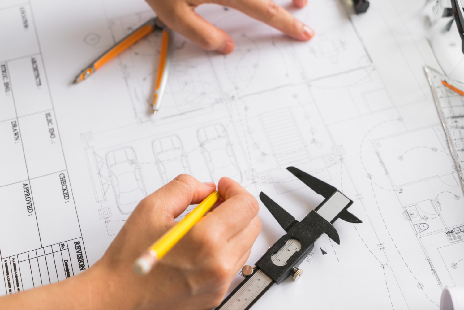 Engenheiro realiza conferência dimensional com paquímetro sobre planta técnica detalhada. A precisão da leitura está diretamente associada à aplicação correta dos critérios GD&T, assegurando função e intercambialidade.