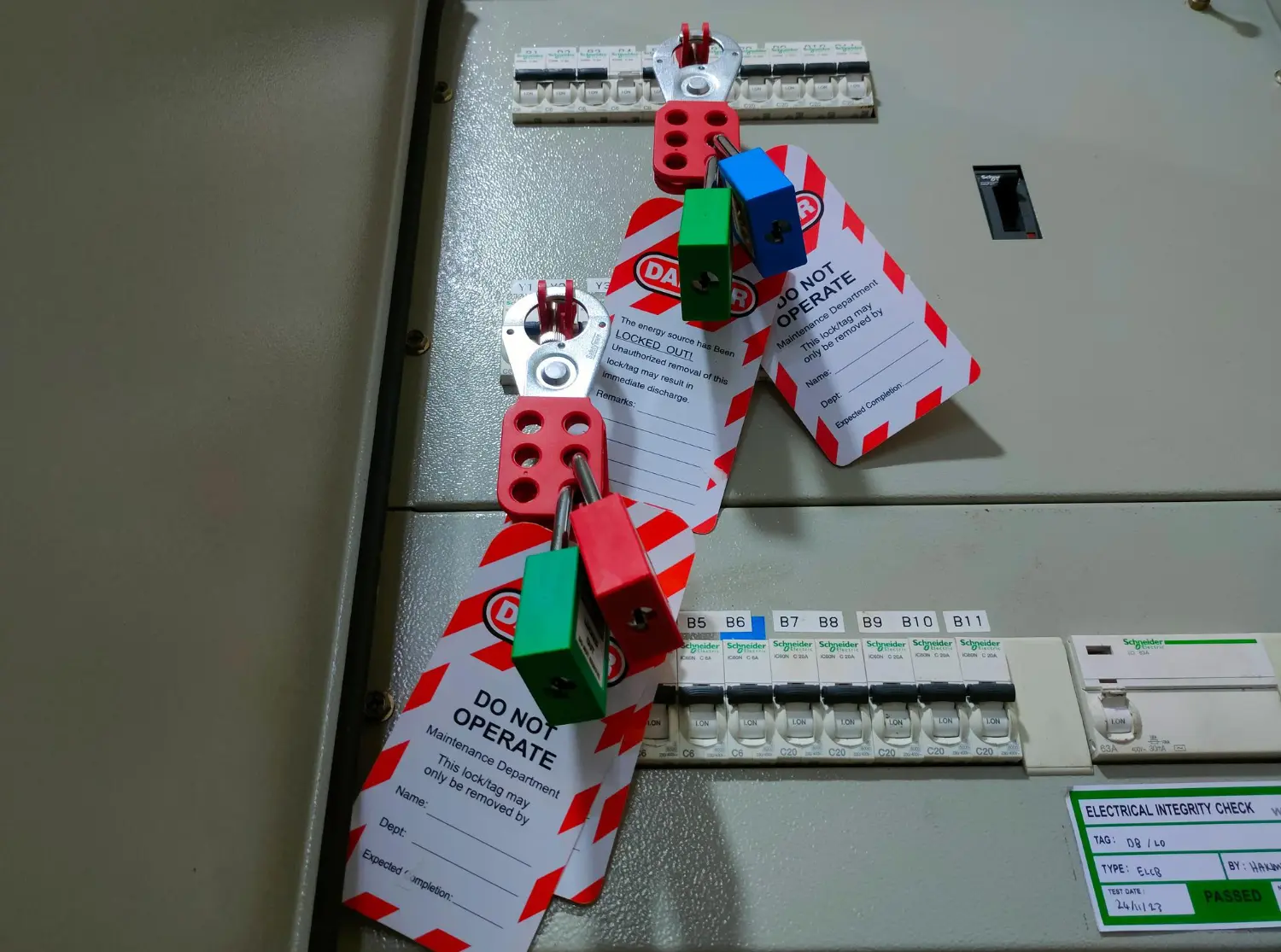 Equipe técnica aplica o bloqueio físico e a sinalização padronizada no painel elétrico, garantindo a execução do procedimento LOTO.TO com responsabilidade compartilhada. Cada cadeado representa um trabalhador protegido pela interrupção controlada da energia, conforme exigido pela NR 10.-Curso LOTOTO