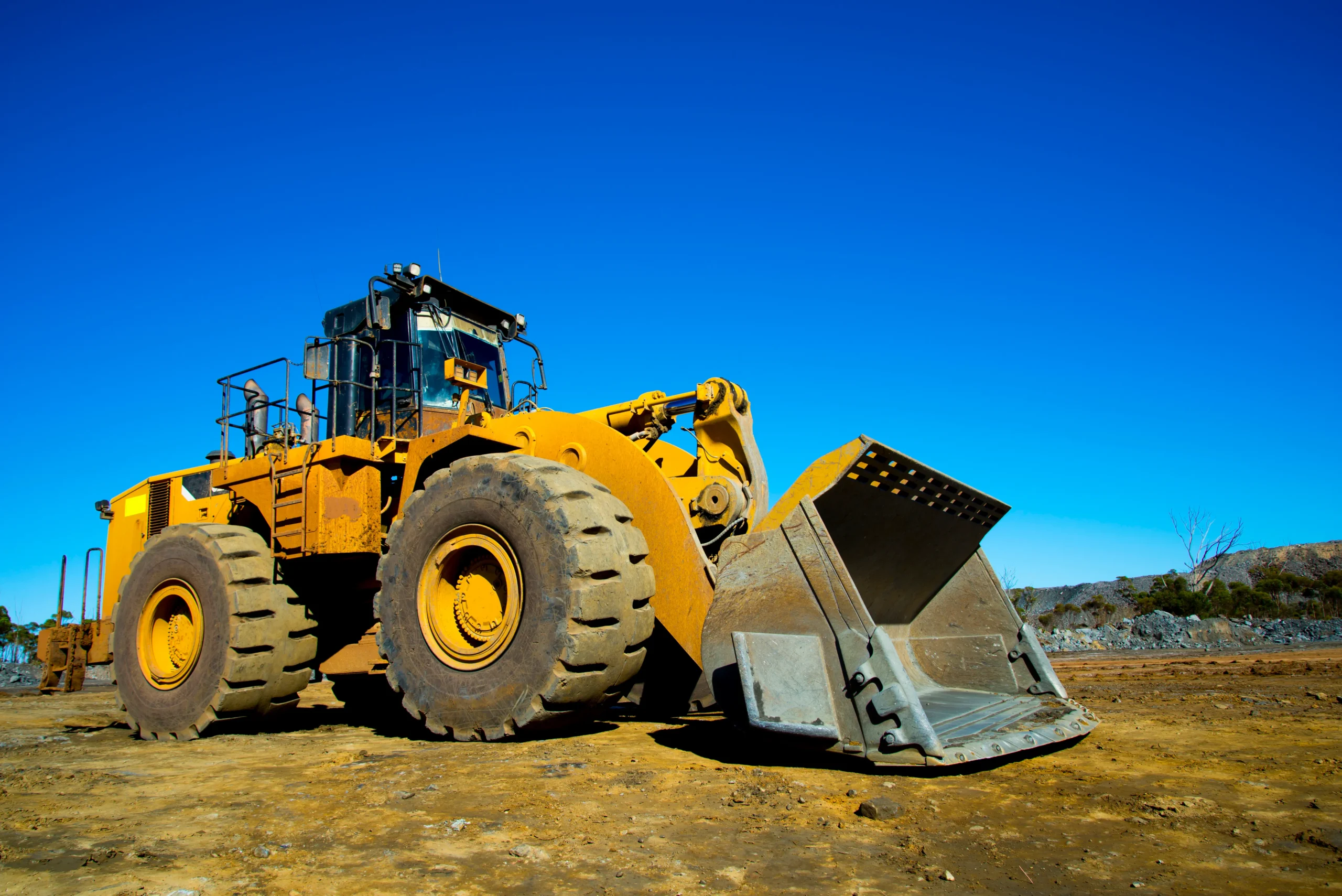 Pá carregadeira de grande porte em área de mineração seca – pronta para operação com alta produtividade.