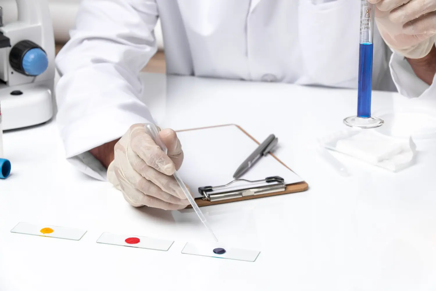 Técnico realiza preparo e dosagem de reagentes em lâminas de teste, seguindo protocolos rígidos de condicionamento e análise térmica para ensaios de inflamabilidade e desempenho térmico.