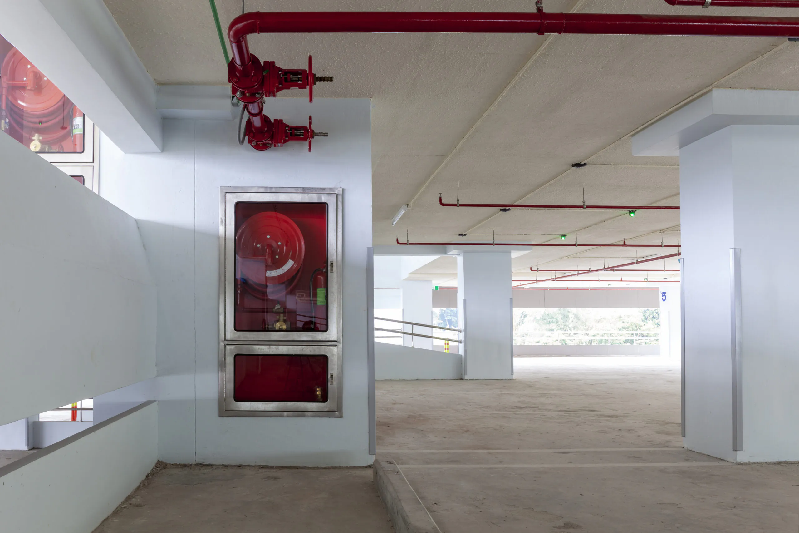 Instalação hidráulica interna com abrigo de mangotinho, conectada a uma malha superior de tubulações para acionamento rápido em situações emergenciais. - Curso NFPA 15.