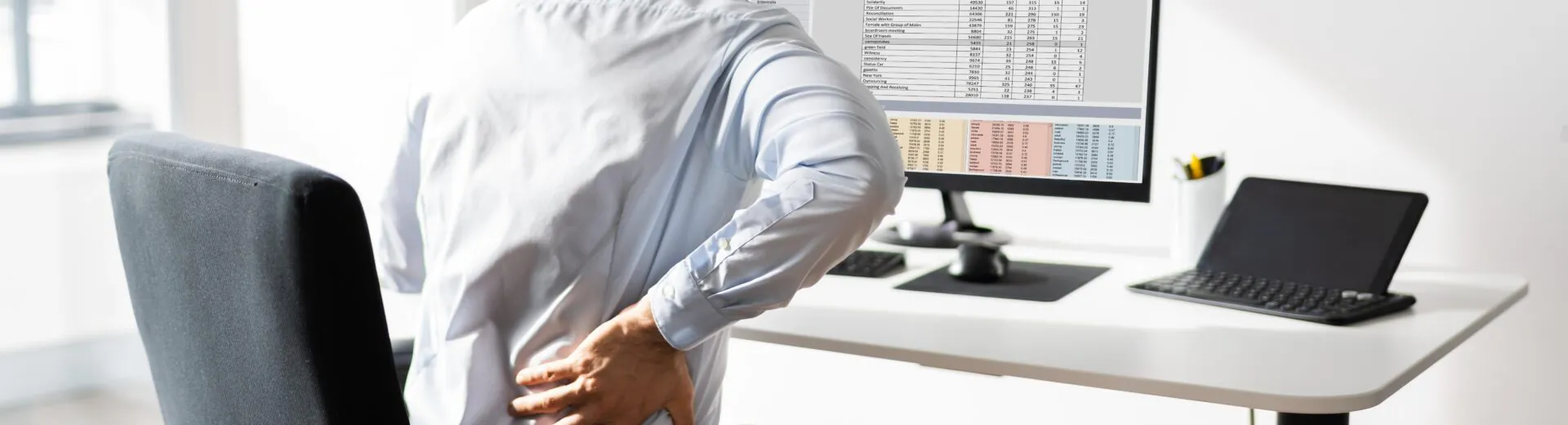 trabalhador sentado diante de um computador em uma estação de trabalho.