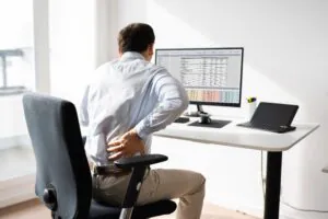 trabalhador sentado diante de um computador em uma estação de trabalho.