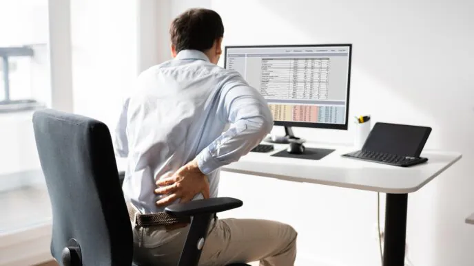 trabalhador sentado diante de um computador em uma estação de trabalho.